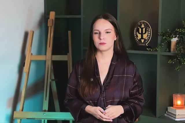 Luana Fontana Petri serena, de mãos juntas, no estúdio