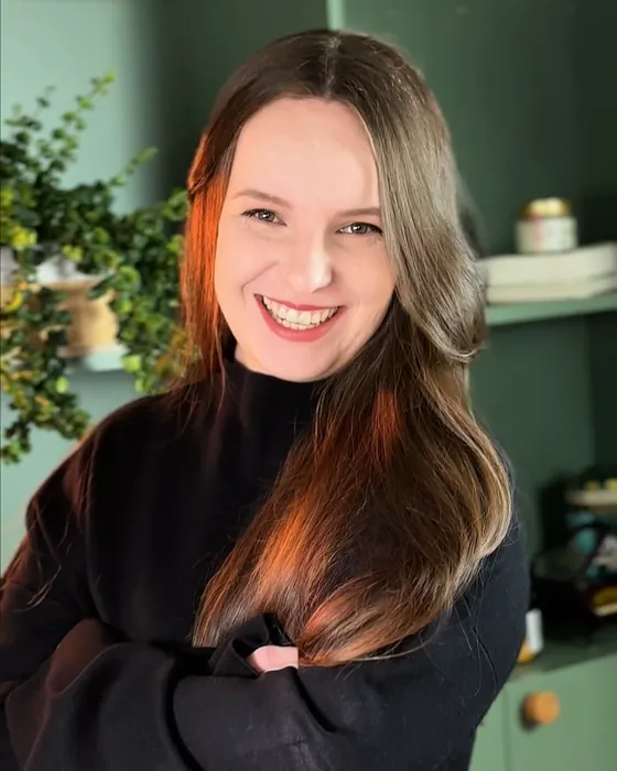 Luana Fontana Petri sorrindo, de braços cruzados