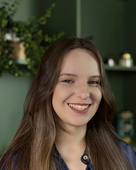 Luana Fontana Petri sorrindo, de blusa azul-marinho